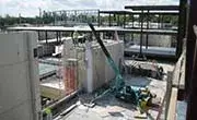 Maeda MC305C compact spider crane lifting materials on an elevated construction site
