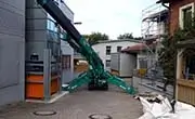 Maeda MC815C mini spider crane set up in a narrow residential access area with outriggers deployed